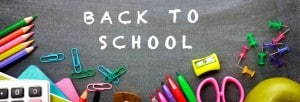 Back to school on chalkboard surrounded by school supplies